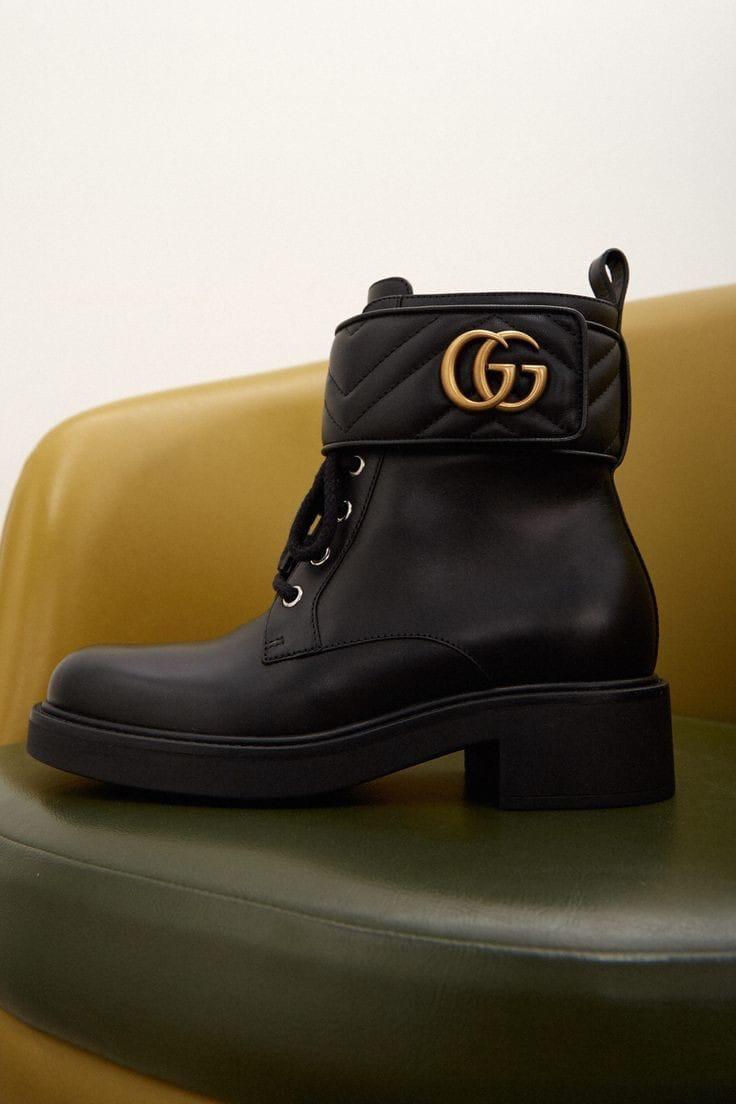 Black Gucci Women’s Premium Leather Boots with Brand Box  leather boot with gold logo on a green surface