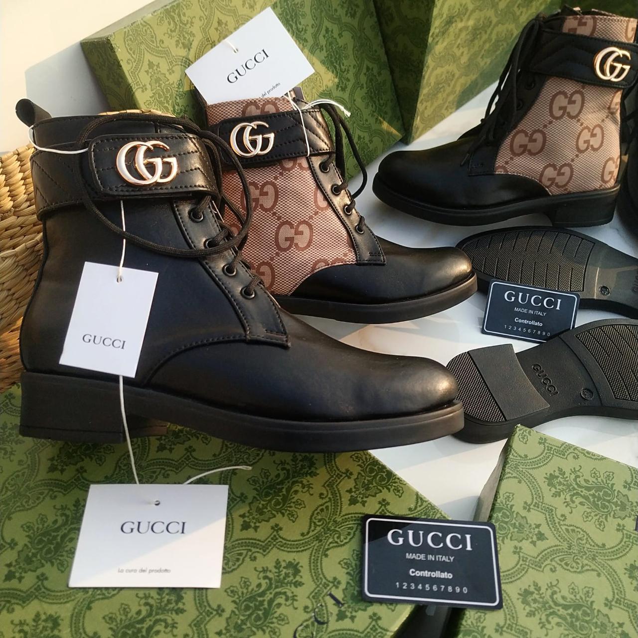 Gucci Women’s Premium Leather Boots with Brand Box Gucci black leather boots with patterned insole on a green fabric background