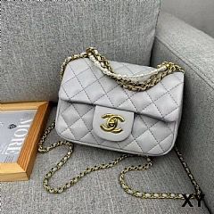 Grey Chanel Mini Flap Bag quilted handbag with gold chain on a gray sofa