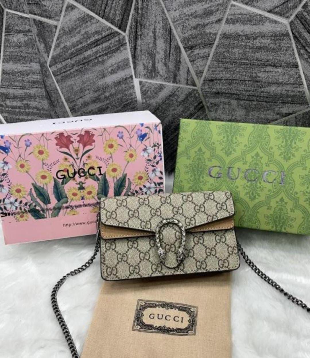 Beige Gucci Dionysus Mini .Gucci handbag with floral and patterned boxes on a textured surface