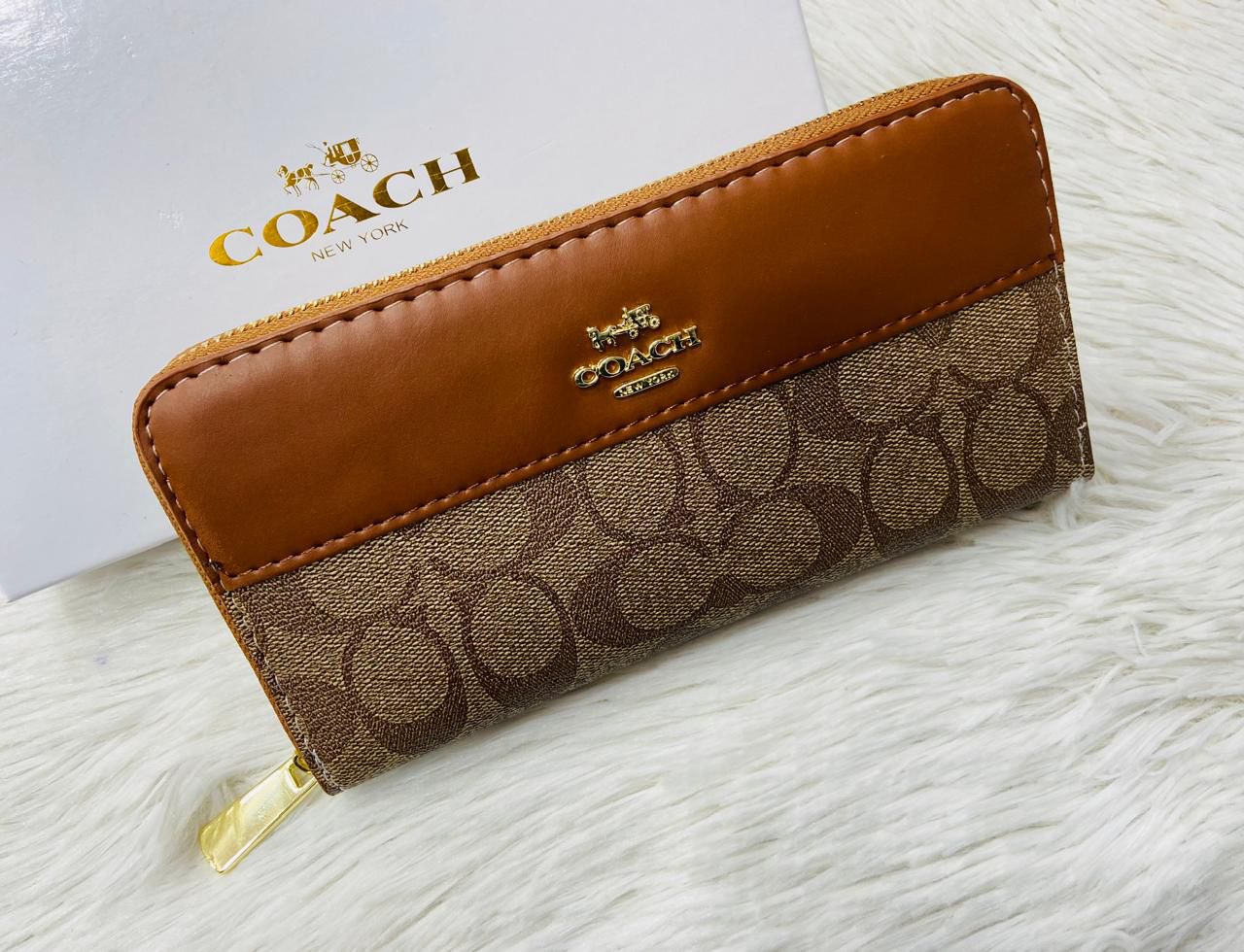 Brown Coach High-Quality Handy Wallet Coach wallet with brown leather and patterned fabric on a white surface