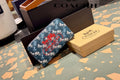 Blue Coach Charter Signature Wallets for Women wallet with red floral design on a Coach branded box