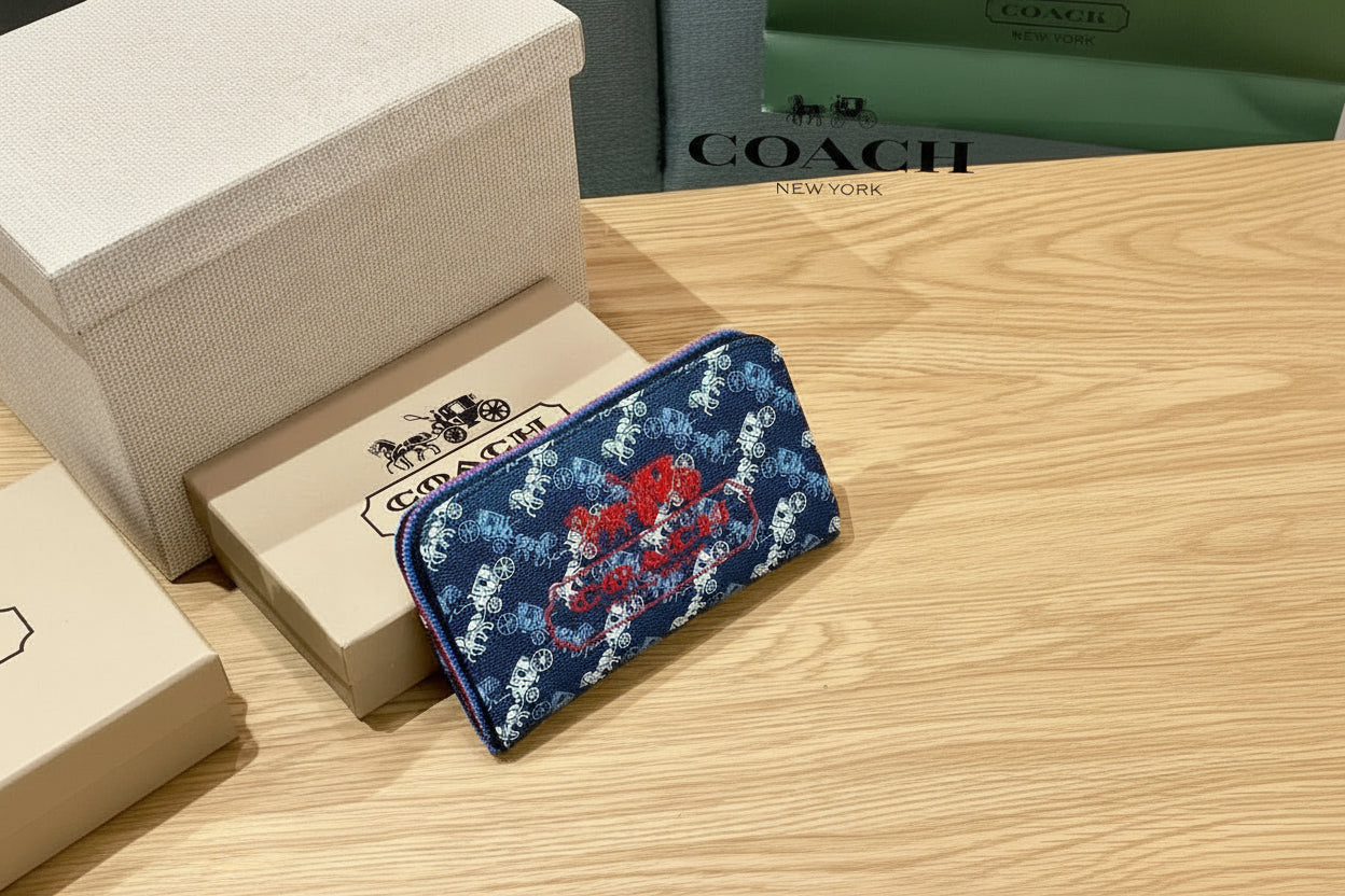 Bue Coach Charter Signature Wallets for Women Coach wallet with horse and carriage design on a wooden surface with Coach packaging.