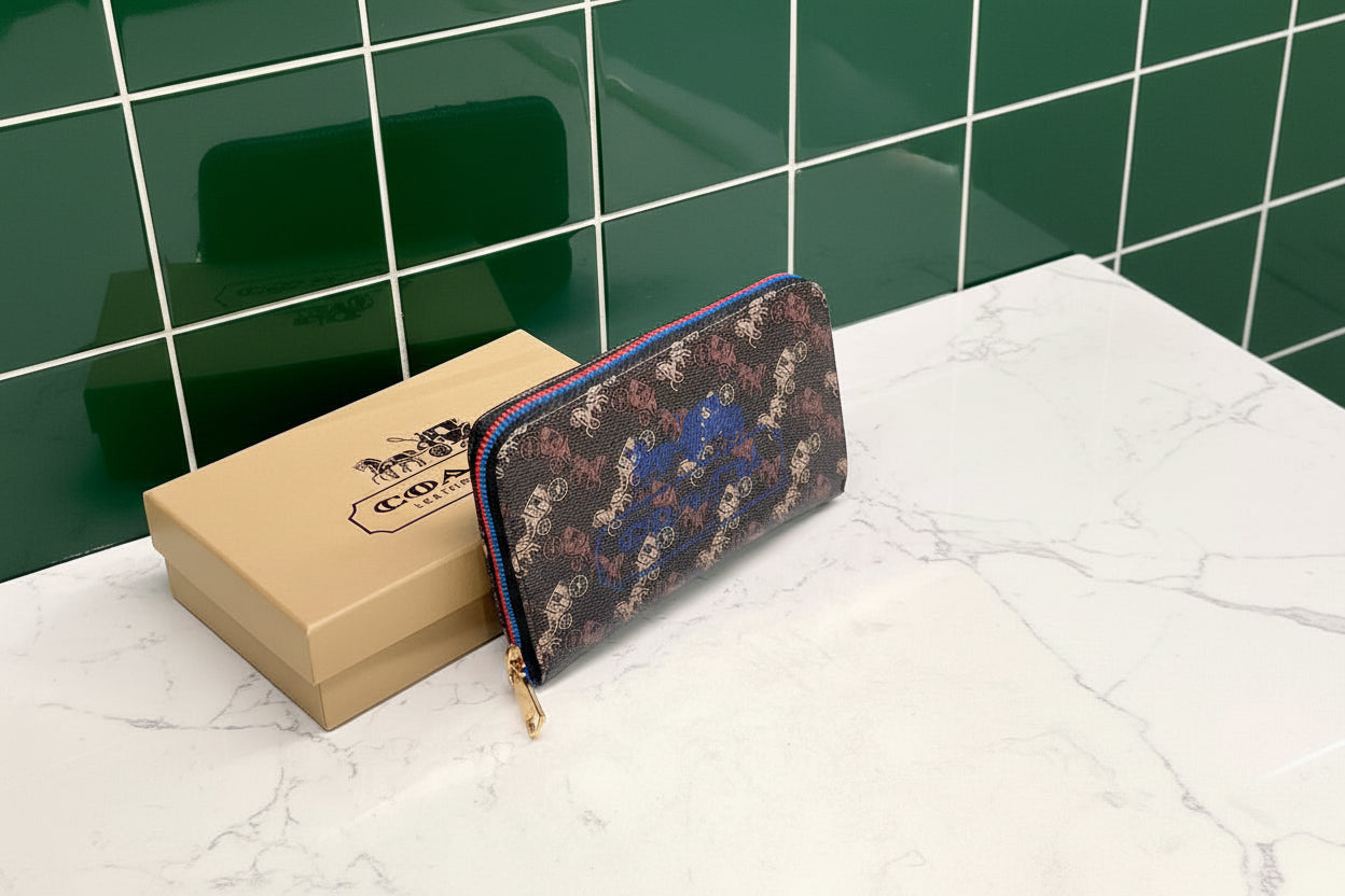 Brown Coach Charter Signature Wallets for Women Coach wallet with floral pattern and gold zipper on a white surface with Coach box in the background.