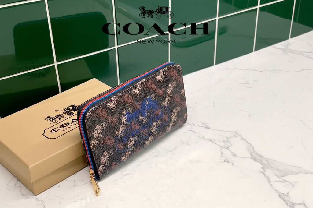 Brown Coach Charter Signature Wallets for Women Coach wallet with floral pattern and gold zipper on a white surface with Coach box in the background.