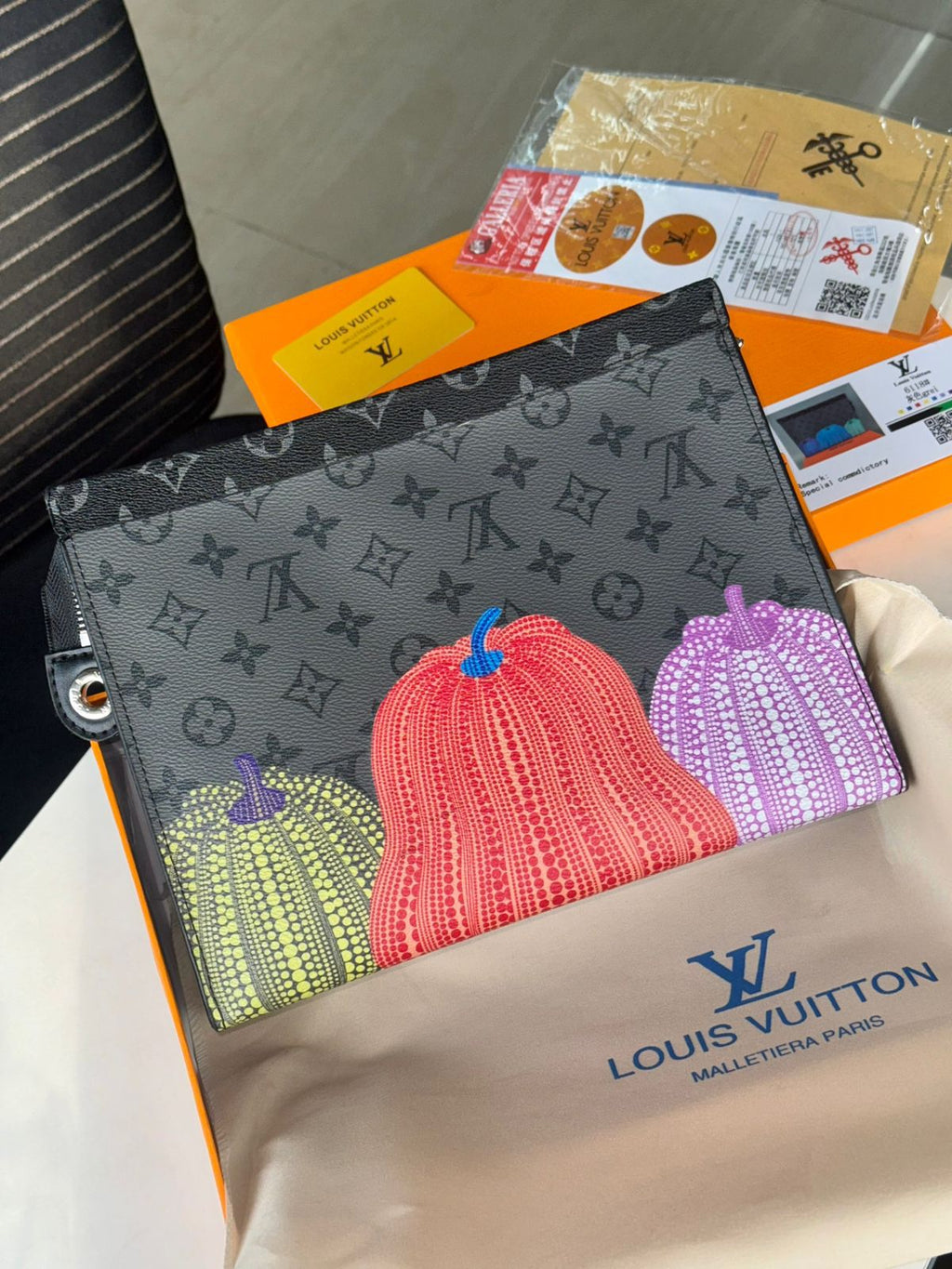 Orange Louis Vuitton Unisex Reverse Pochette Louis Vuitton pouch with colorful pumpkins design on a beige Louis Vuitton pouch.