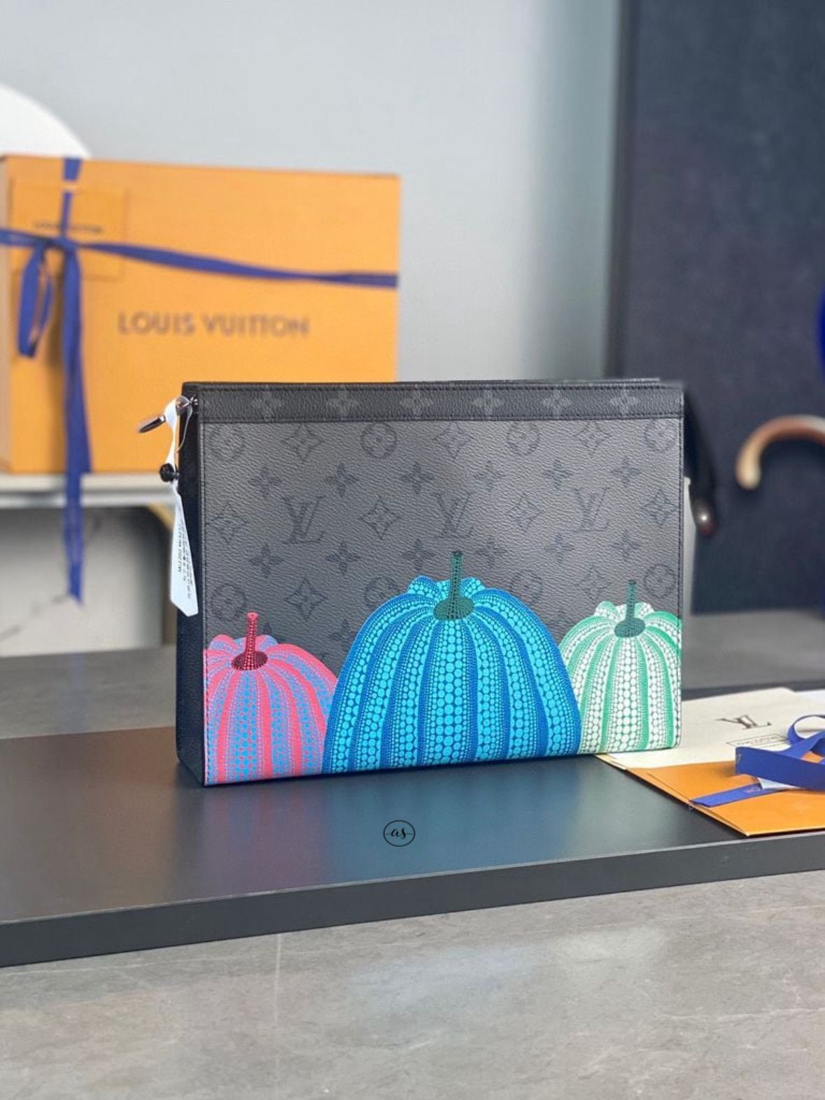 Louis Vuitton Unisex Reverse Pochette Louis Vuitton pouch with colorful pumpkins design on a table