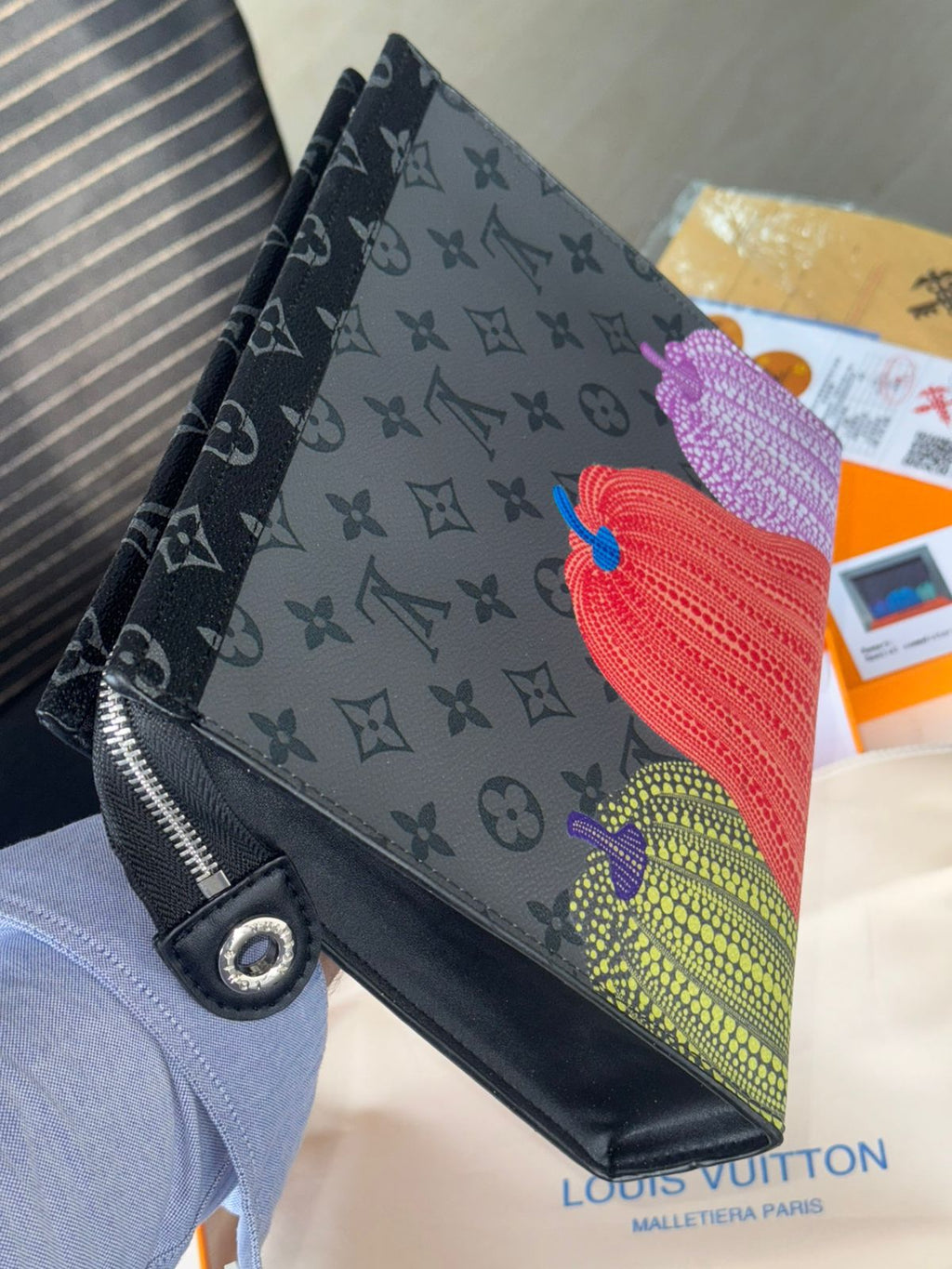 Louis Vuitton Unisex Reverse Pochette Louis Vuitton wallet with a colorful embroidered design on a blurred background