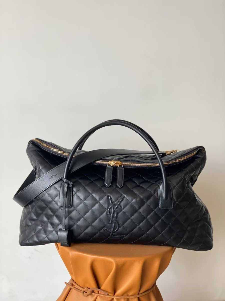 Black YSL Giant Quilted Leather Weekend Duffle Bag Black quilted handbag on a beige surface with a neutral background