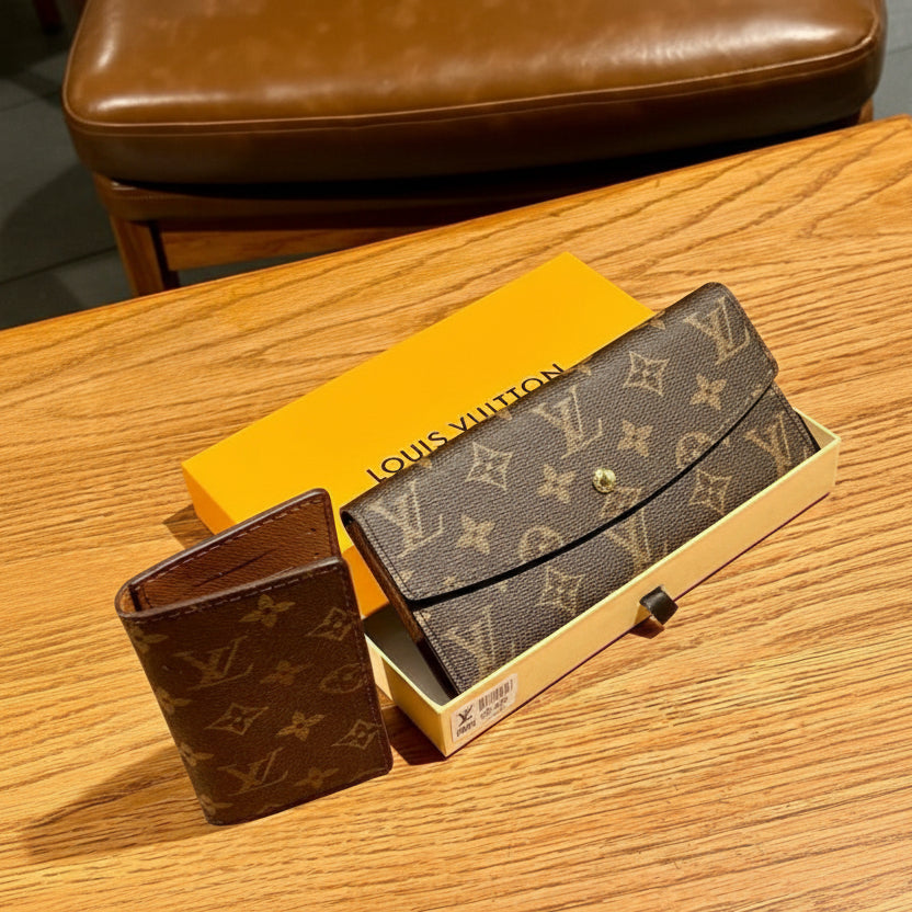 Tan Louis Vuitton wallet and box on a wooden surface