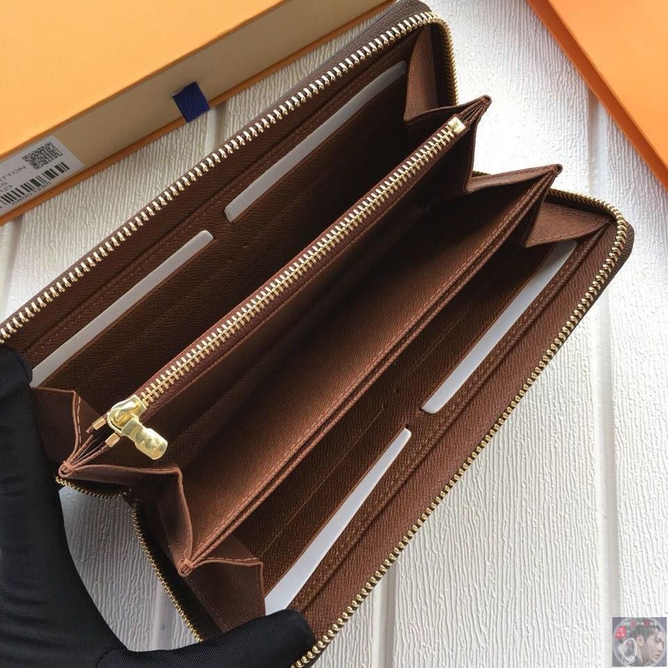 Brown leather wallet with gold zipper on a white background