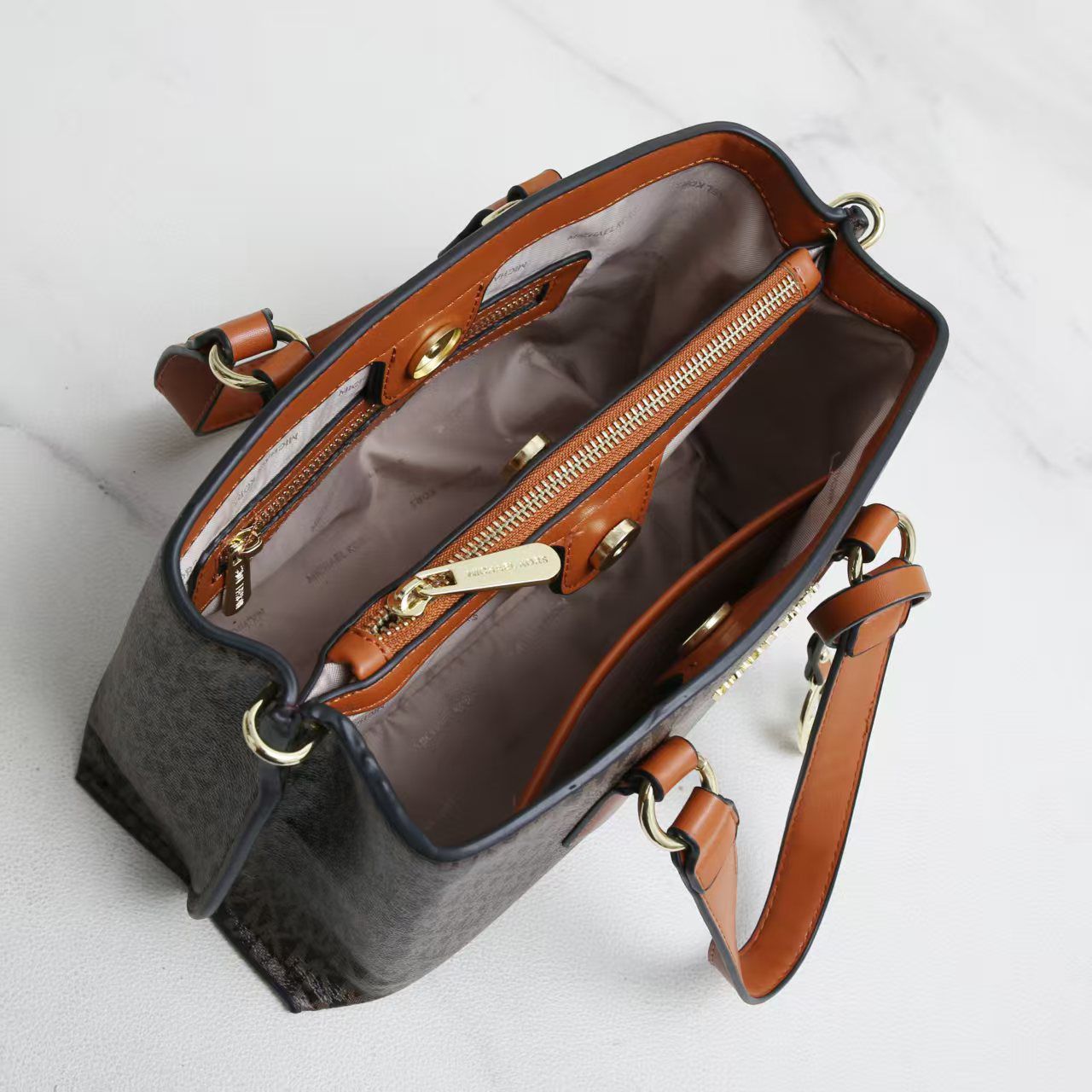 Tan Michael Kors Marilyn Medium Satchel Brown leather handbag with gold zippers on a white background