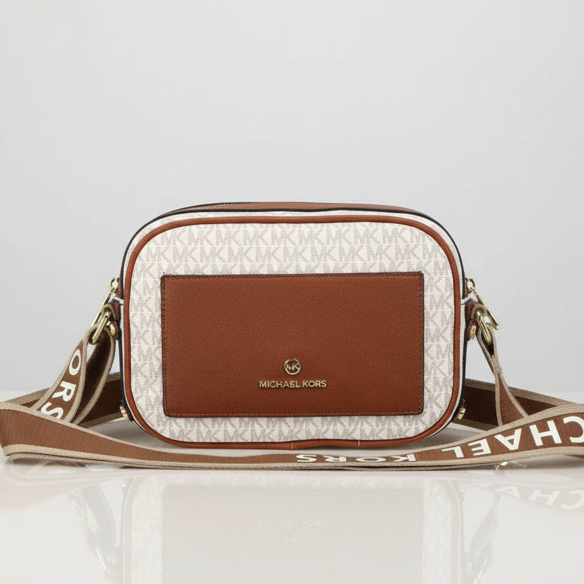 White Michael Kors Kinsley Sling Bag Michael Kors handbag on a light surface with a decorative background