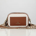 White Michael Kors Kinsley Sling Bag Michael Kors handbag on a light surface with a decorative background