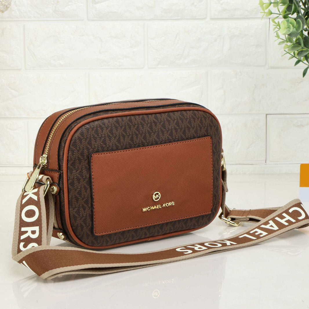 Tan Michael Kors Kinsley Sling Bag Brown handbag with visible brand logo on a light background