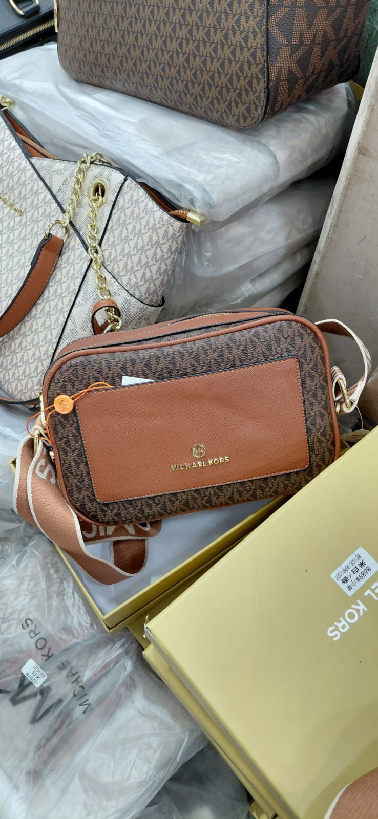 Tan Michael Kors Kinsley Sling Bag Brown handbag with visible logo on a white surface