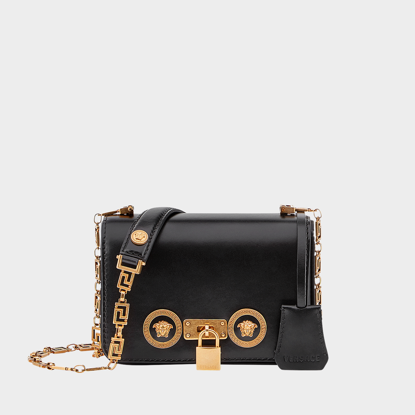 Black Flower medusa handbag with gold accents on a light gray background