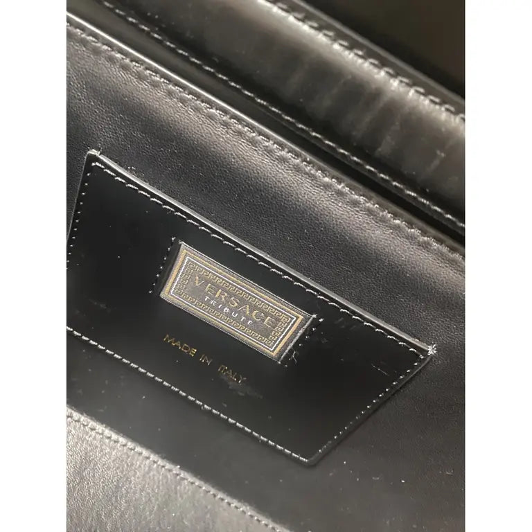 Black medusa Close-up of a Versace logo on a black leather product.