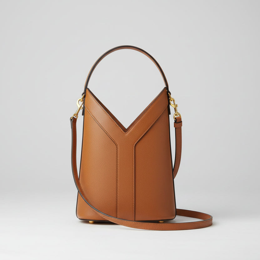 Brown YSL Y Top Handle Bucket Bag  leather handbag on a white surface with a brand name visible