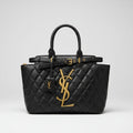Black YSL Saint Laurent Medium Tote Bag quilted handbag with gold logo on a reflective surface